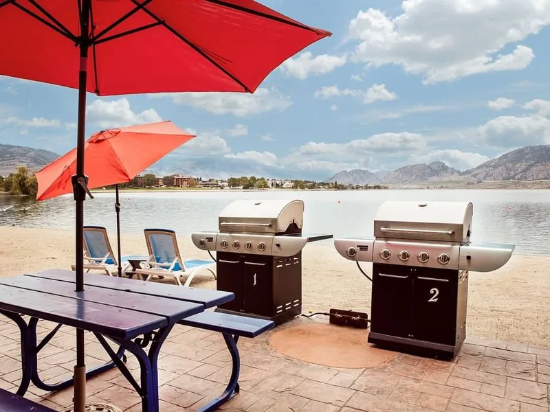 Outdoor guest barbecues, picnic tables and umbrellas beside the hotel beach