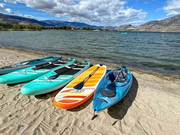 Complimentary kayaks and paddleboards lined up on the Osoyoos Beach Hotel shoreline