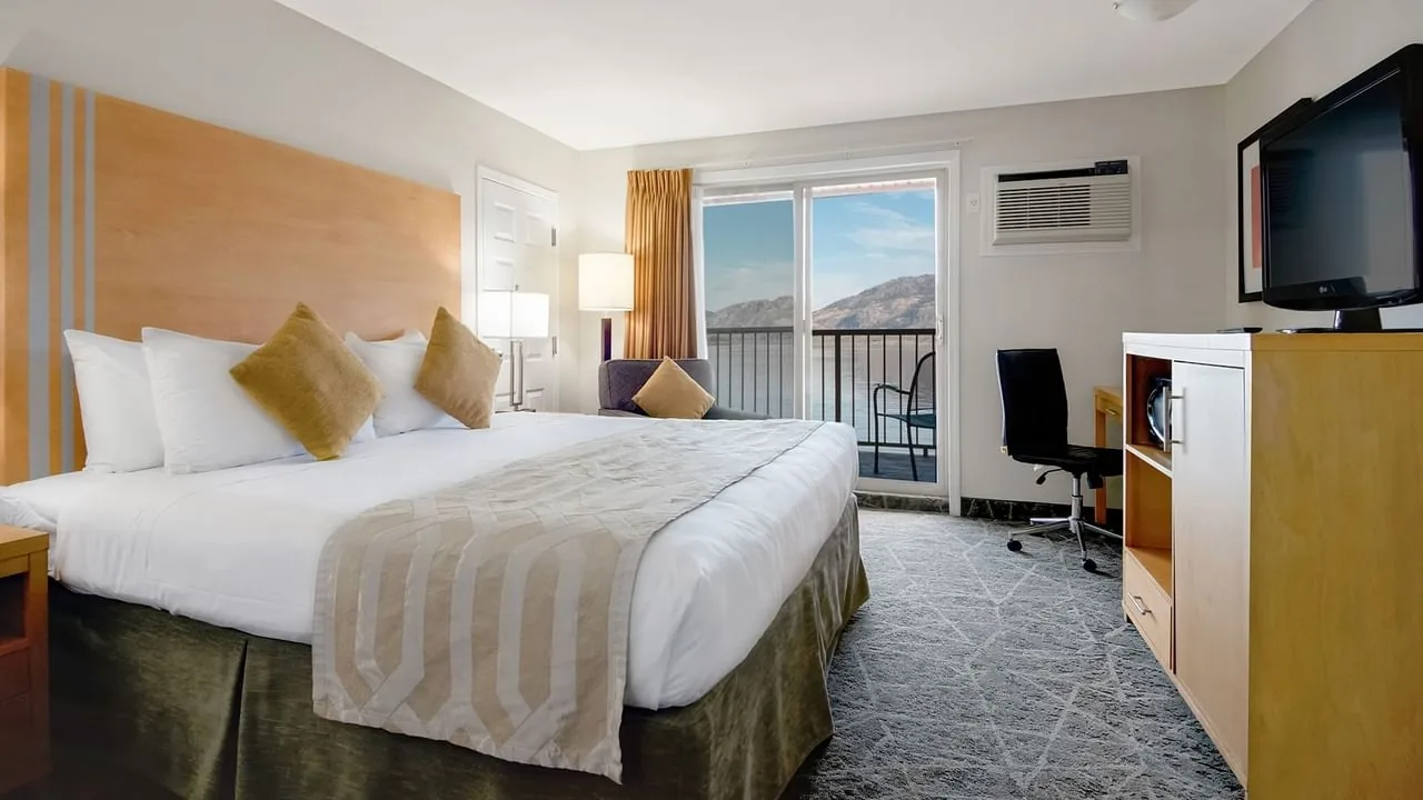 Lake-side hotel room with a king bed and balcony