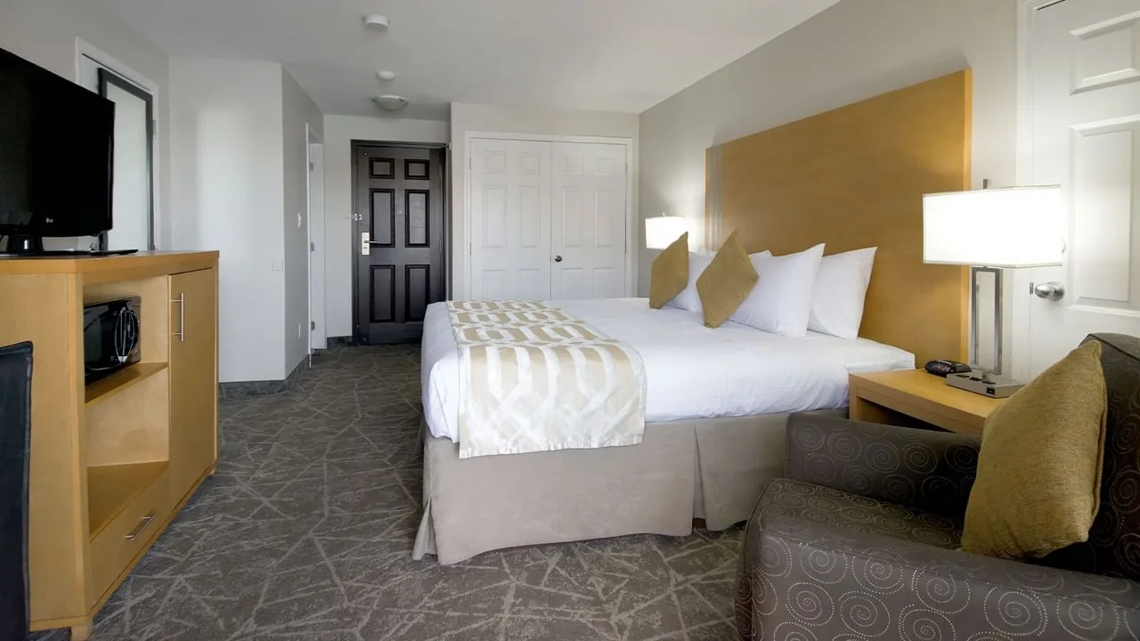 Hotel room with a work desk, television and balcony door